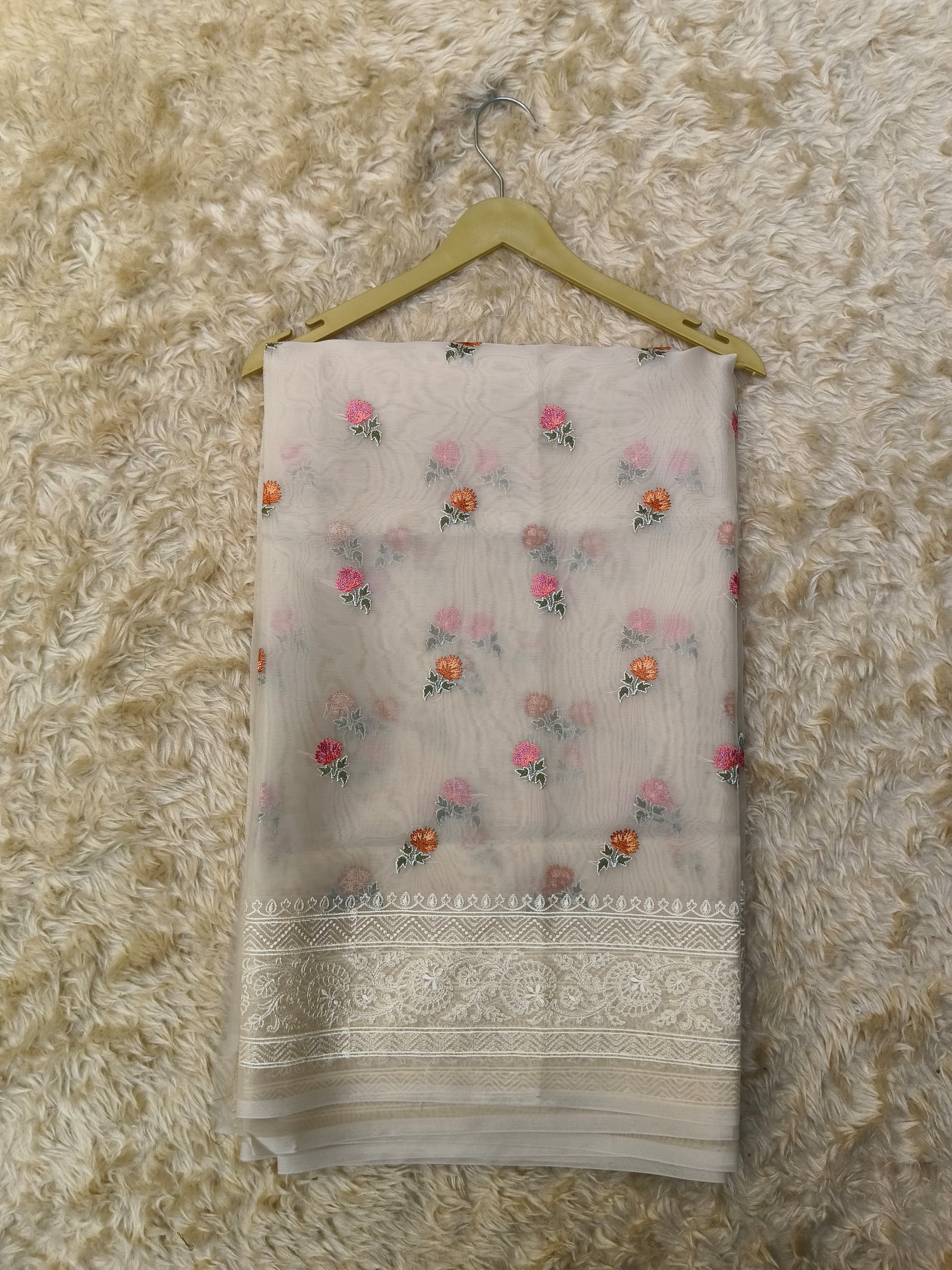 Folded saree with floral patterns on a textured surface