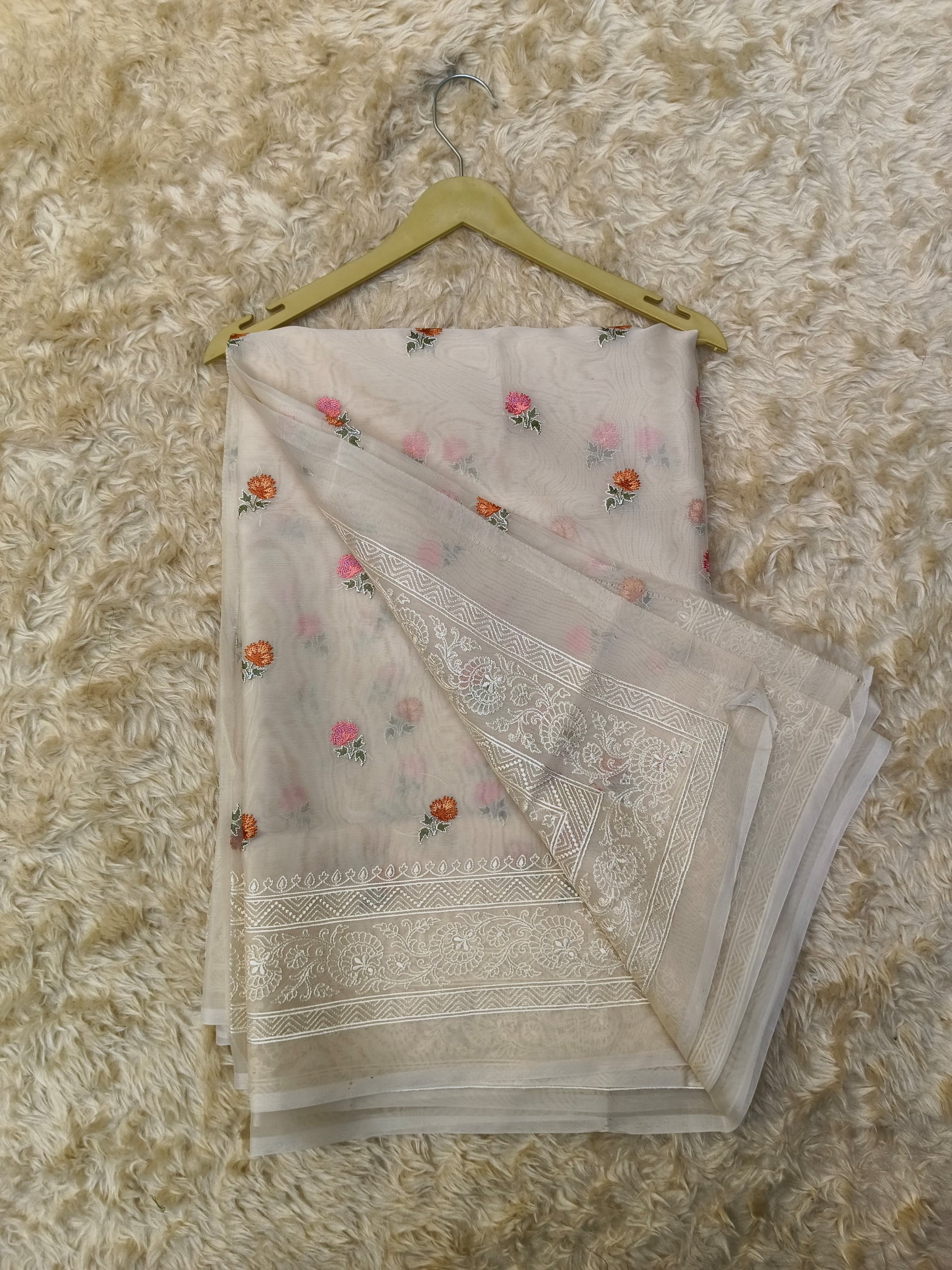 Folded saree  with floral patterns on a textured surface