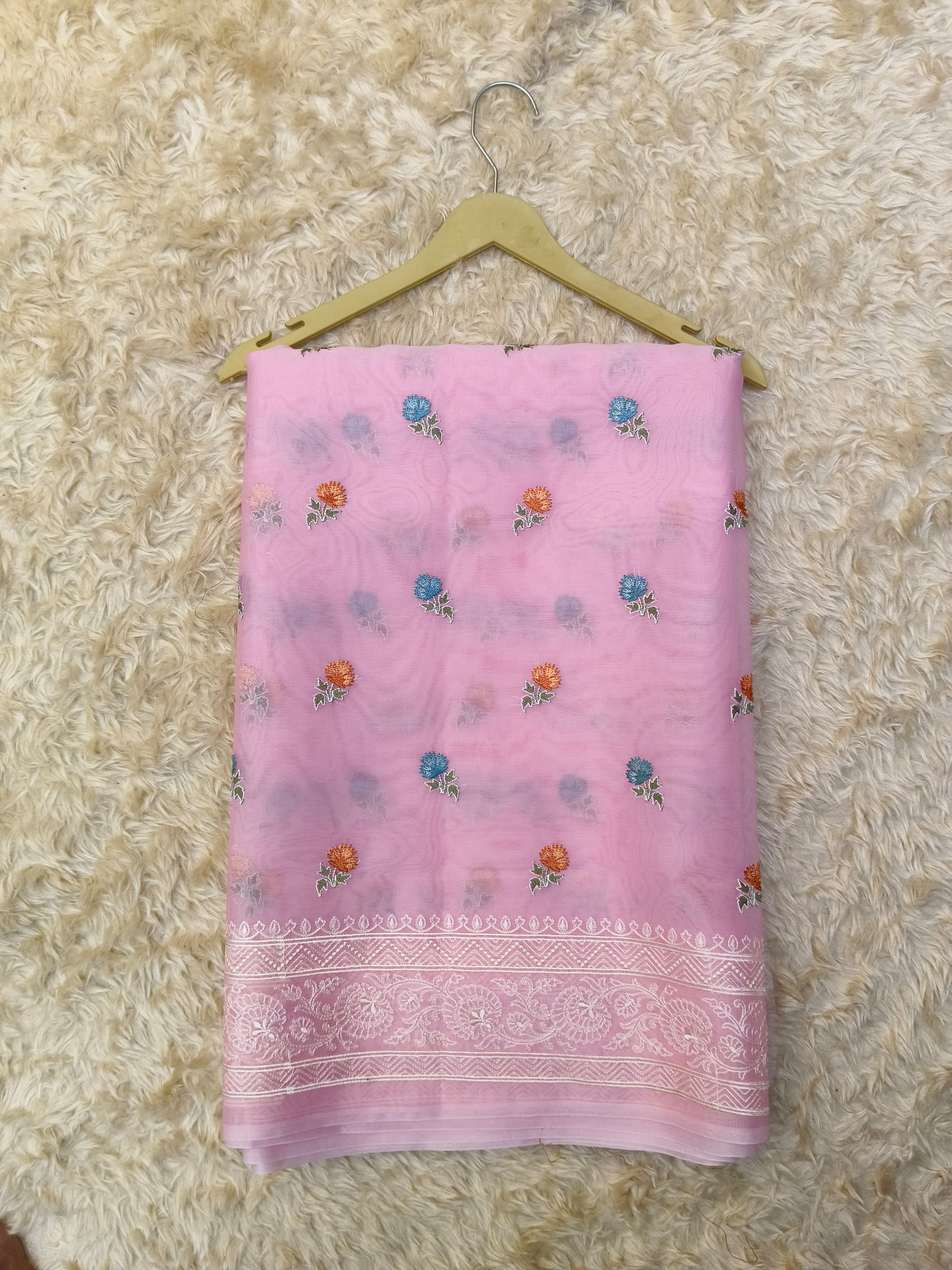 Pink Saree with floral patterns on a beige textured background