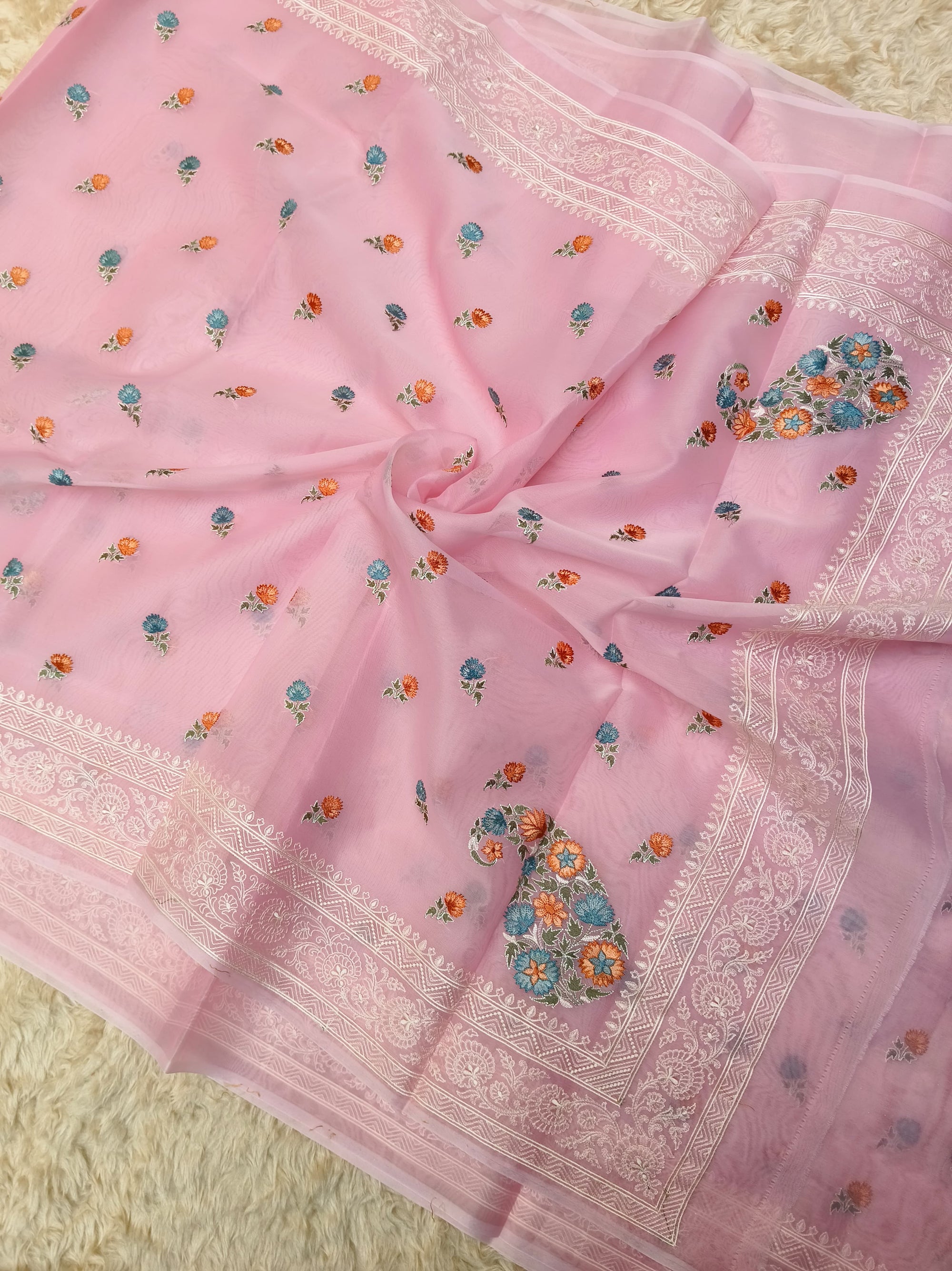 Pink saree with floral patterns on a textured surface