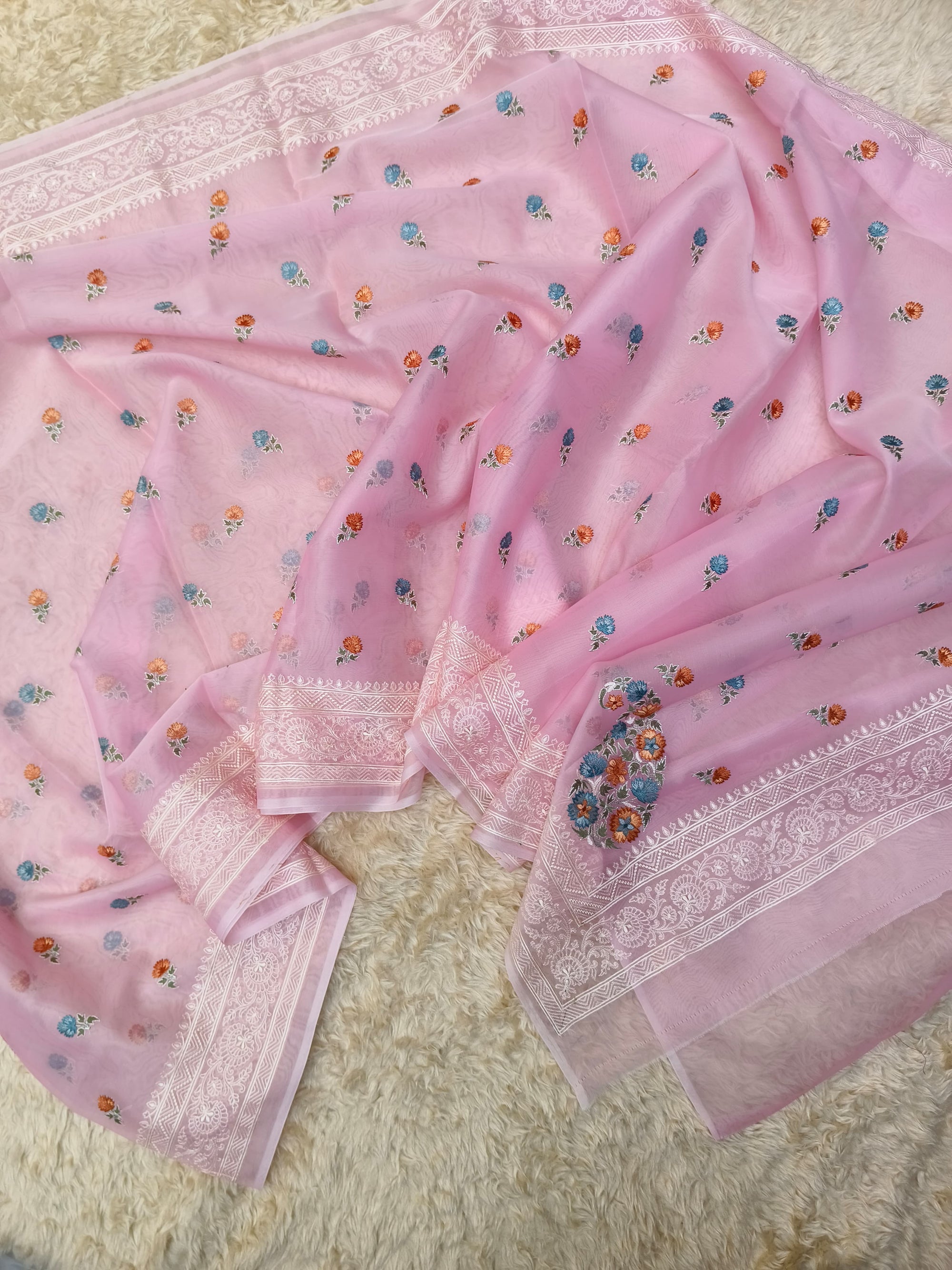 Pink saree with floral patterns on a textured surface