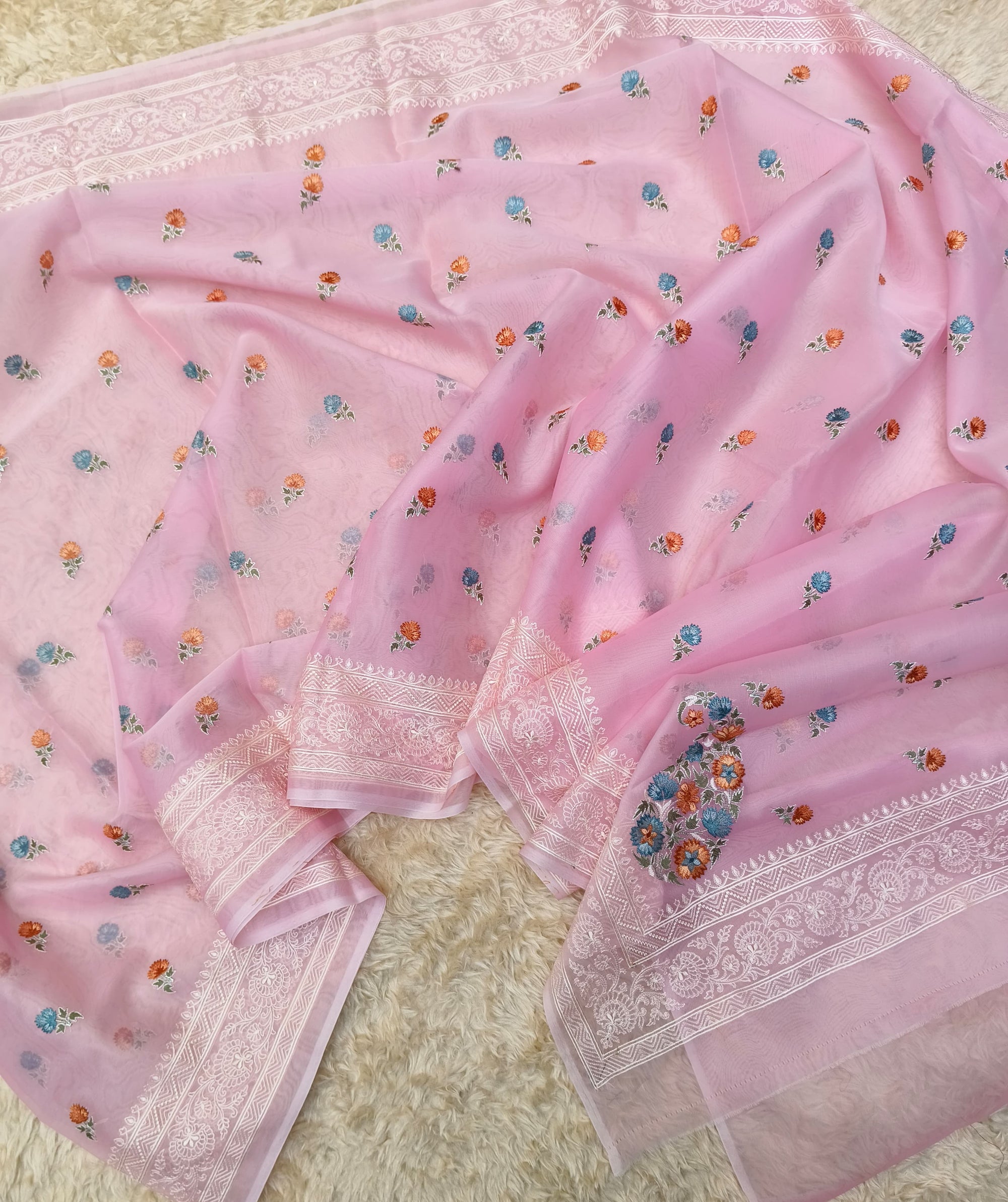 Pink saree with floral patterns on a textured surface